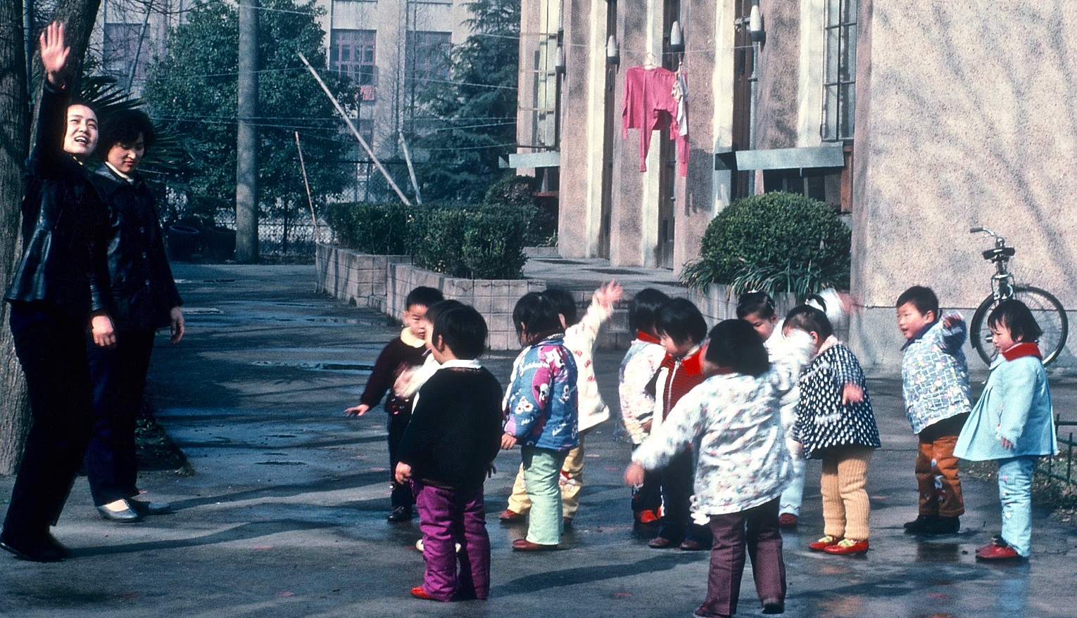 Children waving in a Chinese schoolyard — scanned film, 1980s